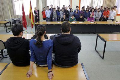 Profesores y alumnos leen un manifiesto en apoyo a los detenidos (de espaldas) en Políticas.