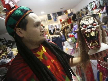 Un empleado de una tienda de disfraces donostiarra sostiene una m&aacute;scara.