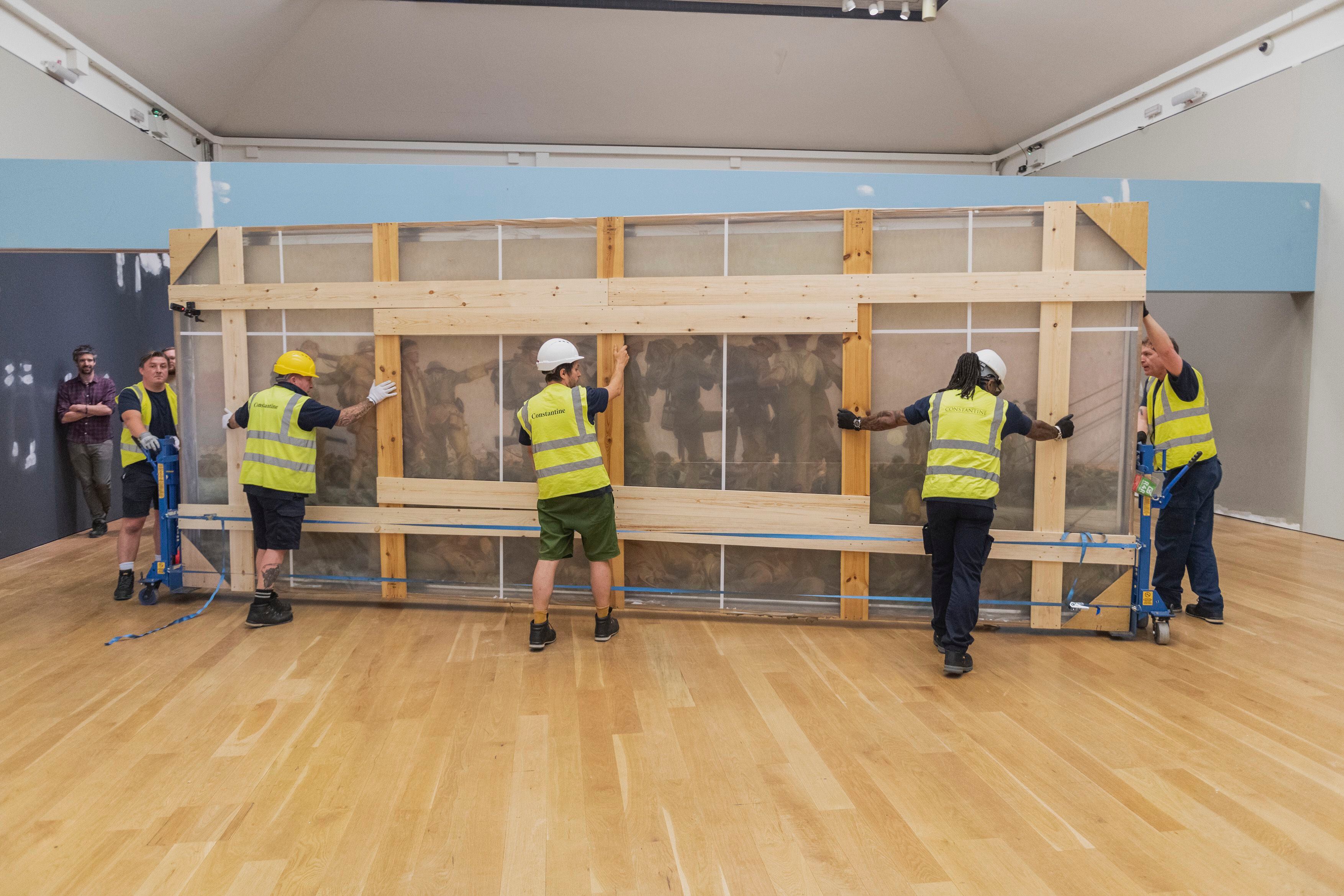 Un grupo de operarios devuelven al Museo de la Guerra Imperial el lienzo de Sargent el 19 de julio, después de su restauración.