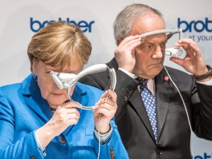 La excanciller alemana Angela Merkel y el expresidente suizo Johann Schneider-Ammann prueban unas gafas de realidad aumentada en una feria tecnológica celebrada en Hanover, Alemania, en 2016.