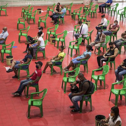 Varias personas esperan para recibir sus vacunas contra la covid-19 en el centro de vacunación del Centro Olímpico Juan Pablo Duarte en Santo Domingo, República Dominicana.