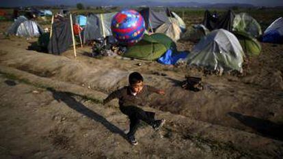 Boy plays with a ball at a makeshift camp for refugees and migrants at the Greek-Macedonian border near the village of Idomeni
