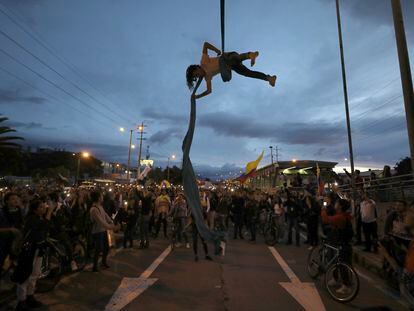 Un hombre hace acrobacias colgado de un puente durante una protesta en Bogotá, el 27 de noviembre de 2019.