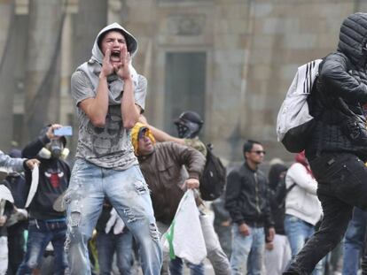 Un manifestante, en la plaza de Bolívar de Bogotá este jueves. En vídeo, la Policía dispersa con gases lacrimógenos a los manifestantes.