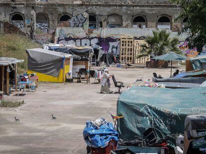 Una mujer traslada una silla en el campamento de la calle Bilbao.