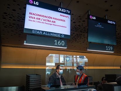 Trabajadores de Avianca atienden a los pasajeros varados por el cierre de Viva Air y Ultra Air, en el aeropuerto El Dorado en Bogotá este 30 de marzo.