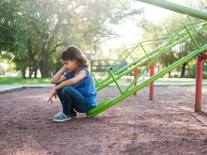 Una niña triste en un patio de recreo, en una fotografía ilustrativa.