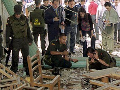 La policía colombiana examina los restos de la cafetería tras el atentado.