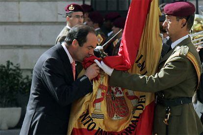 El ministro de Defensa, José Bono, acompañado por la cúpula militar, besa la bandera en un acto militar de despedida.