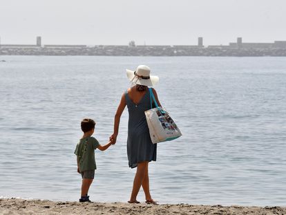 Una mujer y un niño pasean por la playa de El Zapillo en Almería, este lunes.