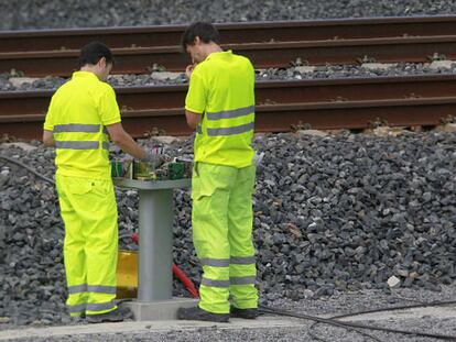 Trabajadores de Adif revisan una baliza en la curva de A Grandeira tras el accidente.