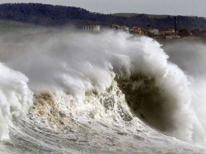 Una ola rompe hoy junto a la bocana del puerto de Santander