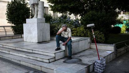 Un pintor espera a lograr clientes, en el centro de Atenas.