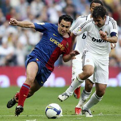Xavi disputa el balón con Raúl.