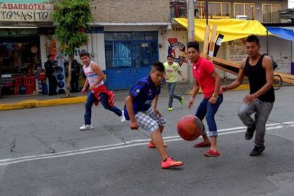 Jóvenes mexicanos juegan fútbol en el barrio de Iztapalapa.