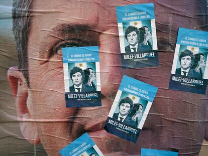 Pequeños carteles electorales de Javier Milei, del partido La Libertad Avanza, pegados sobre un enorme anuncio de Sergio Massa, de Unión por la Patria, en Buenos Aires el 15 de noviembre.