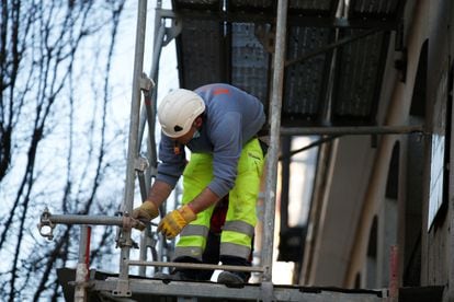 Un obrero de la construcción trabaja sobre un andamio en una imagen de archivo.
