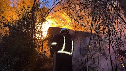 Los bomberos intentan apagar el incendio originado el sábado junto al pantano de San Juan, el pasado agosto.