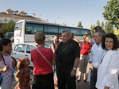 El arzobispo de Granada, Javier Martínez, junto al autobús fletado por la diócesis.