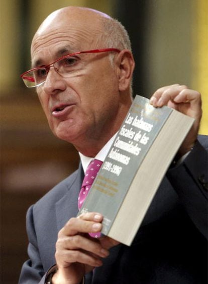 El portavoz de CiU, Josep Antoni Duran, muestra un libro sobre las balanzas fiscales.