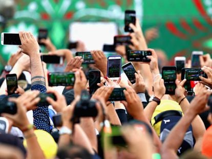 Decenas de personas utilizan sus teléfonos inteligentes para grabar un evento en Ciudad de México.