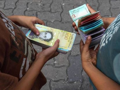 Dos niños cuentan billetes en Caracas.