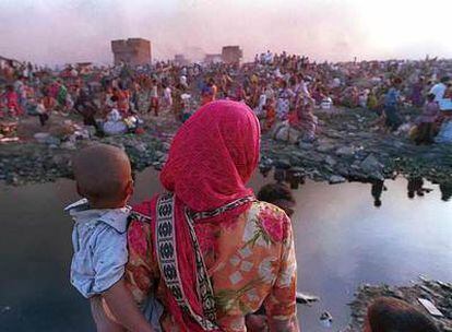 Una mujer con su hijo en brazos en un barrio de Nueva Delhi (India).