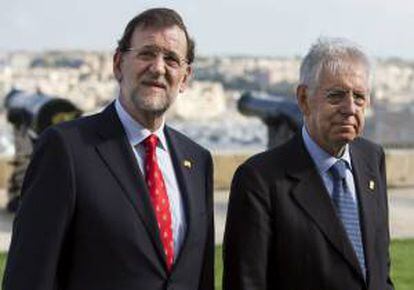 El presidente del gobierno español, Mariano Rajoy (i), y el primer ministro italiano, Mario Monti, caminan juntos después de posar para una foto de familia de la cumbre del grupo "Cinco más Cinco" en La Valeta, Malta, el pasado 5 de octubre. EFE/Archivo