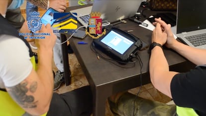 Agentes de la Policía emplean un dispositivo habitual para copiar la información de uno de los móviles de los detenidos. La imagen procede de un vídeo de la Policía sobre la operación en Tenerife.