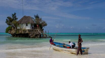 Unos turistas se dirigen en barca al restaurante The Rock de Paje en Zanzibar, Tanzania.