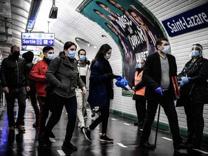 Varios usuarios con mascarilla en el interior de la estación Saint-Lazare del metro de París.