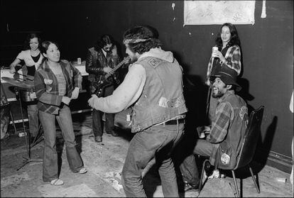 Inside their rent-free, and city-owned, clubhouse in the South Bronx, members of the Chingalings, a Puerto Rican motorcycle gang, play music, dance, and drink, New York, New York, January 15, 1975.