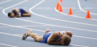 Dos atletas tendidos sobre el tartán del estadio Luzhniki tras la carrera de los 20km marcha.