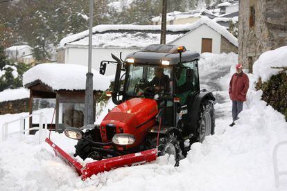 Un tractor trata de despejar un pueblo de Asturias tras las nevadas.