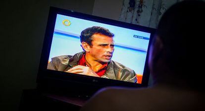 Un hombre ve una entrevista a Capriles en Globovisión.
