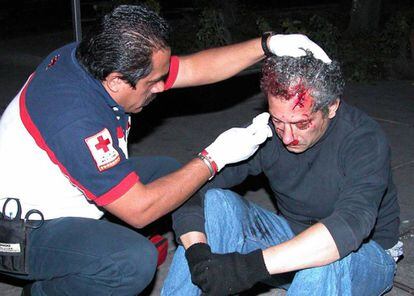 Un sanitario atiende a José Luis Calva tras ser atropellado por un coche cuando trataba de huir.