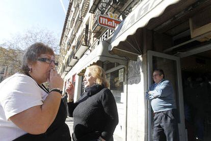 Dos mujeres fuman en el exterior de un bar de Madrid.