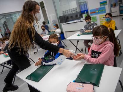 Una profesora del colegio donostiarra Summa Aldapeta reparte hidrogel a los alumnos tras las vacaciones de Navidad, el lunes.