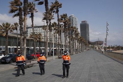 Tres Agents Cívics (Agentes Cívicos) del Ayuntamento de Barcelona patrullan por el paseo marítimo de la ciudad, este martes, cuando se cumple el décimo día del estado de alarma decretado por el Gobierno por la pandemia de coronavirus.