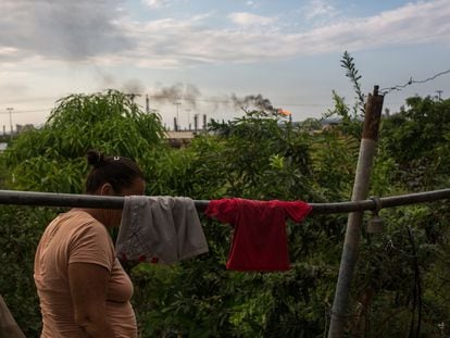 Una vecina cuelga su ropa, cerca de las instalaciones de la refinería Puerto La Cruz de Petróleos de Venezuela, en el Estado de Anzoátegui, en una fotografía de archivo de 2021.