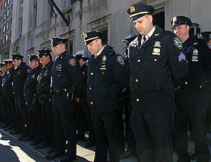 Policías de Nueva York guardan cabizbajos un minuto de silencio.