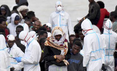 Un grupo de migrantes espera, este viernes, para desembarcar en el puerto de Catania (Italia).