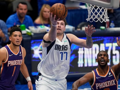 Luka Doncic lanza una bandeja ante la mirada de Devin Booker y Chris Paul.