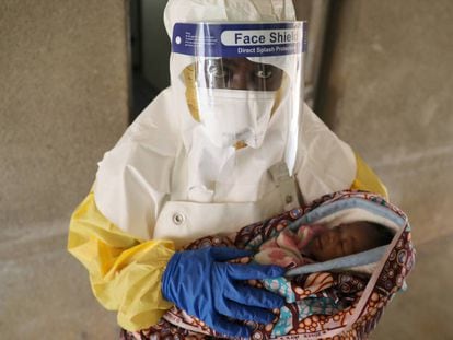 Una sanitaria lleva a un bebé enfermo con el virus del Ébola en un hospital en Oicha, en la República Democrática del Congo.