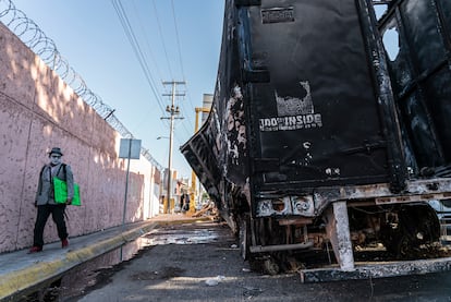 Un hombre camina junto a un trailer quemado en Culiacán, el 6 de enero.
