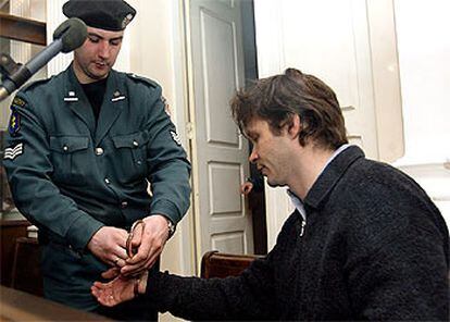 Un policía quita las esposas a Cantat en el tribunal de Vilna donde se le juzga.