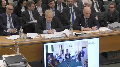 Boris Johnson, durante la comparecencia, este miércoles, ante el Comité de Privilegios del Parlamento para dar explicaciones sobre el 'partygate'. Una pantalla muestra la foto de una de las presuntas fiestas en Downing Street.