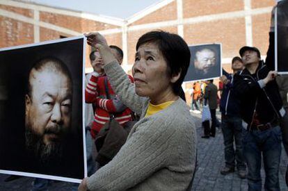 Una simpatizante de Ai Weiwei muestra un afiche del artista disidente chino durante una protesta en Shanghái