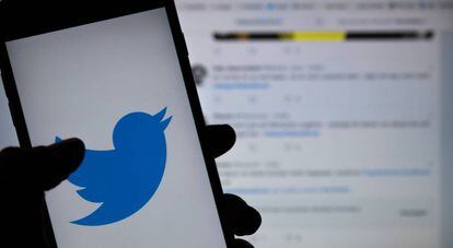 El logo de Twitter, en un teléfono móvil frente a una pantalla con la red social.