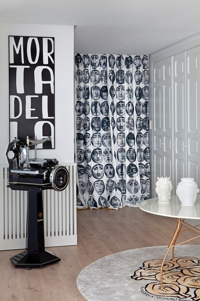 In the hall, three of Negrini's great passions.  The classic Fornasetti print.  One of the mortadella slicers that he collects with a metal plate, designed by Sapey, which alludes to the cold meat in question.  The rug, designed by Teresa Sapey, with a tortellini motif.